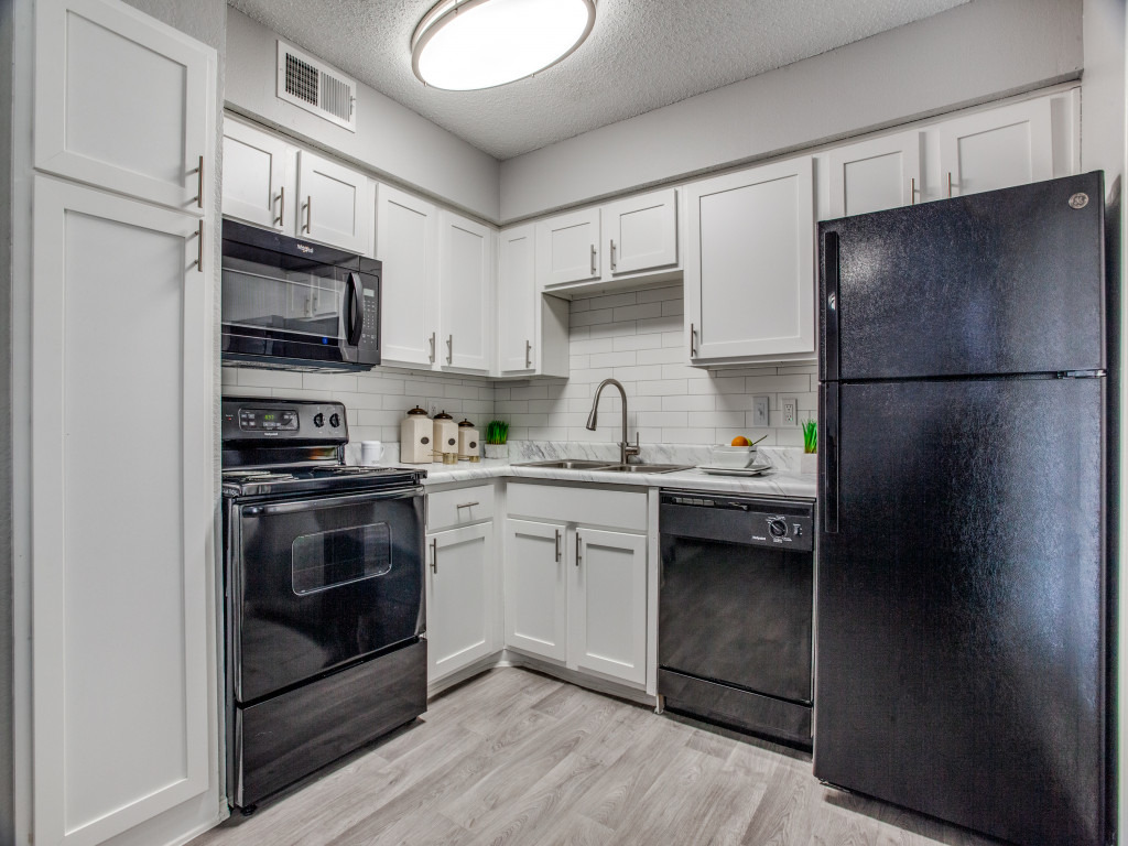 model kitchen with vinyl wood-look flooring, refinished countertops and black appliances