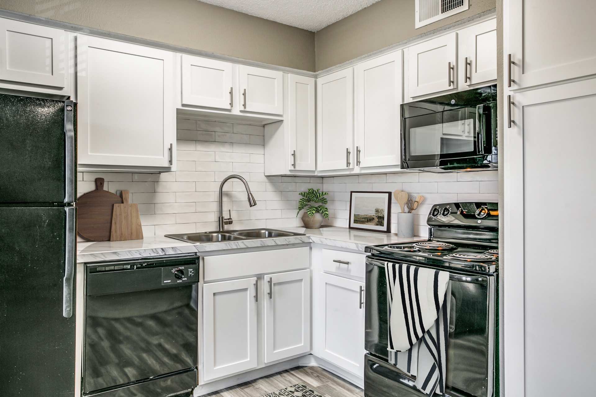 L-shaped kitchen with black appliances